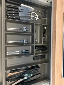 a drawer filled with lots of knives and scissors at Spacious Apartment 1BR with Sofa bed near Atomium, Expo 12 and ING Arena in Wemmel