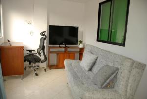 a living room with a couch and a flat screen tv at Comfortable Itagüí Stay in Itagüí