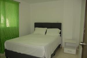 a bed with white sheets and pillows in a bedroom at Comfortable Itagüí Stay in Itagüí