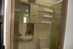 a bathroom with a sink and a toilet and a mirror at Comfortable Itagüí Stay in Itagüí