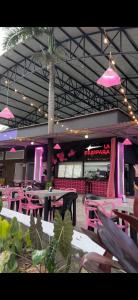 a restaurant with pink tables and chairs and pink lights at Hotel Porton De Oriente in Puerto Triunfo