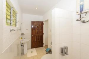 a bathroom with a toilet sink and a wooden door at easy diving and beach resort in Manlocahoc