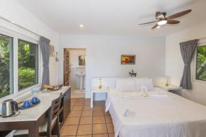 a bedroom with a large white bed and a desk at easy diving and beach resort in Manlocahoc