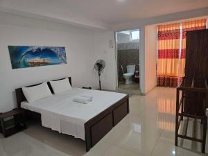 a bedroom with a large white bed in a room at Kandy City View Apartments in Kandy