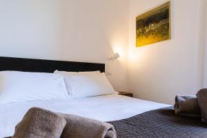 a bedroom with a white bed and a chair at Romantic Pier by Rent All Como in Carate Urio