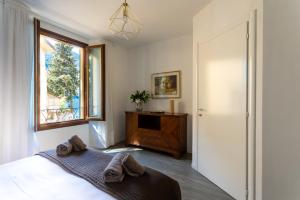 a bedroom with a bed and a window at Romantic Pier by Rent All Como in Carate Urio +36 photos