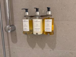 a group of three bottles of soap on a wall at Winchelsea Views in Nanaimo