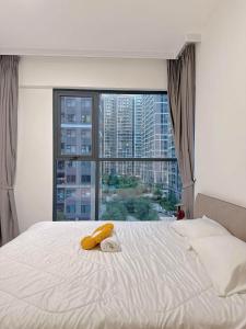 a bedroom with a bed with a large window at Aquar Grand Park in Gò Công