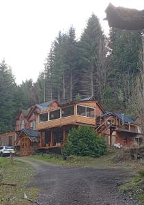 a large wooden house on the side of a road at Hosteria Lekun Lekun in Villa La Angostura