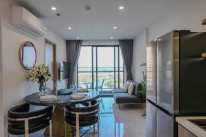 a kitchen and living room with a table and a couch at Aquar Grand Park in Gò Công