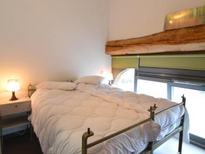 a large bed in a room with a window at Stylish Duplex with Sauna in Modave