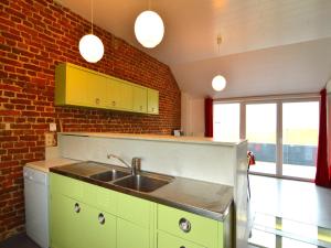 a kitchen with a sink and a brick wall at Stylish Duplex with Sauna in Modave