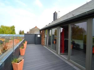 an extension to a house with a deck at Stylish Duplex with Sauna in Modave