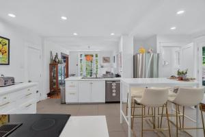a kitchen with white cabinets and a table and chairs at Classic Stockbridge Cottage in Stockbridge