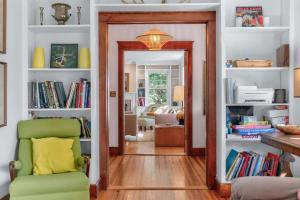 a room with a doorway with a chair and books at Classic Stockbridge Cottage in Stockbridge