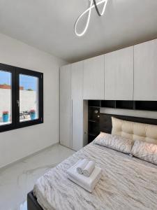 ein Schlafzimmer mit einem großen Bett, auf dem zwei Handtücher liegen in der Unterkunft PoliHome in Monserrato