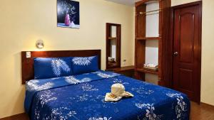 a bedroom with a bed with a stuffed animal on it at Hostal Mariscal Sucre in Tababela
