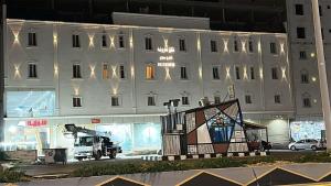 a large white building with a large painting in front of it at أرياف سويت in Al Baha