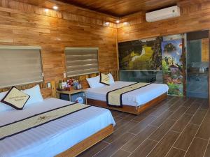 two beds in a room with wooden walls at Xuan Son Lakeside Bungalow in Ninh Binh +165 photos