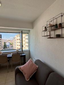 a living room with a couch and a table and a window at L'escapade in Annemasse