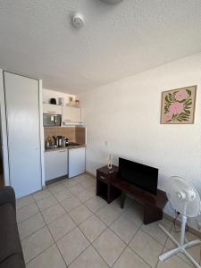 a living room with a flat screen tv and a table at L'escapade in Annemasse