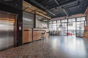 a lobby with a bar and chairs in a building at RedDoorz Plus @ Doorman Guest House in Bandung