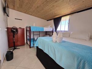 a bedroom with a bunk bed with a blue blanket at Hotel El Balcon de madera in Norcasia