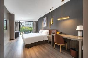 a hotel room with a bed and a desk at Orange Hotel Xiamen City Hall in Xiamen