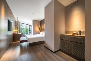 a bedroom with a bed and a kitchen in a room at Orange Hotel Xiamen City Hall in Xiamen
