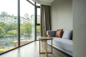 a living room with a couch and a table in front of a window at Orange Hotel Xiamen City Hall in Xiamen