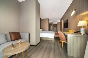 a living room with a couch and a table at Orange Hotel Xiamen City Hall in Xiamen