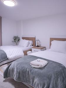 a bedroom with two beds with towels on top of it at Casa Dunia - 2 BR Open Sea View Apartment in Sahl ‘Almā