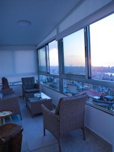 a living room with chairs and tables and windows at Casa Dunia - 2 BR Open Sea View Apartment in Sahl ‘Almā