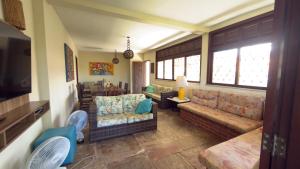 a living room with a couch and chairs and a tv at Casa Sitio Região dos Lagos 1200m2 terreno- S Pedro DAldeia in São Pedro da Aldeia