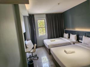 a hotel room with two beds and a window at Hotel 99 Kota Kemuning in Shah Alam +60 photos