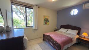 a bedroom with a bed and a desk and a window at Casa Sitio Região dos Lagos 1200m2 terreno- S Pedro DAldeia in São Pedro da Aldeia +68 photos