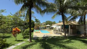 a house with a swimming pool and palm trees at Casa Sitio Região dos Lagos 1200m2 terreno- S Pedro DAldeia in São Pedro da Aldeia