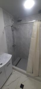 a white bathroom with a shower and a sink at Гостевой дом in Sevan