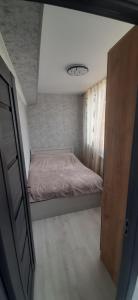 a small bedroom with a bed and a window at Гостевой дом in Sevan