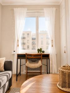 a living room with a desk in front of a window at GuestFirst- Modern Boho Charm in Kallio Helsinki Center in Helsinki