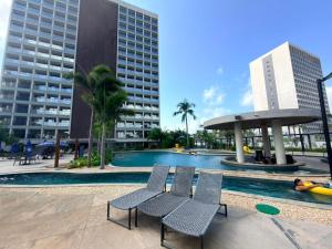 a pool with chairs and buildings in a city at Salinas Premium Resort in Salinópolis