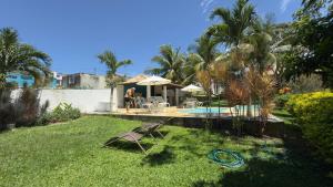 a woman standing in a yard next to a swimming pool at Casa Sitio Região dos Lagos 1200m2 terreno- S Pedro DAldeia in São Pedro da Aldeia