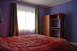 un dormitorio con una cama y una ventana en La Casa Toesca, en Valdivia