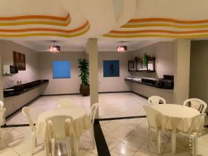 a dining room with white tables and white chairs at Hotel Eldorado de Salinas in Salinas