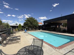 a swimming pool with chairs and a person in the background at The Wesley Boutique Hotel Page, AZ in Page