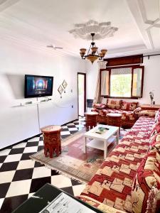 a living room with a couch and a tv at Blue Pearl city in Chefchaouen