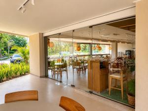 a restaurant with glass walls and tables and chairs at FLAT RESORT LUXO MALIA 215E- Porto de Galinhas - Muro Alto in Porto De Galinhas