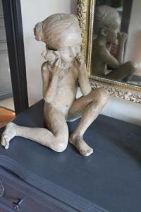 a statue of a little girl sitting in front of a mirror at La Haute Flourie - bed and breakfast -chambres d'hôtes in Saint Malo