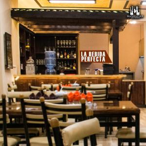 a restaurant with tables and chairs and a bar at Hotel y Restaurante Manhattan in La Tenería