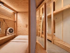 a small bedroom with a bunk bed and a ladder at Ishigaki Guesthouse HIVE in Ishigaki Island